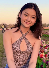 Madison Vuong smiling outside among flowers.