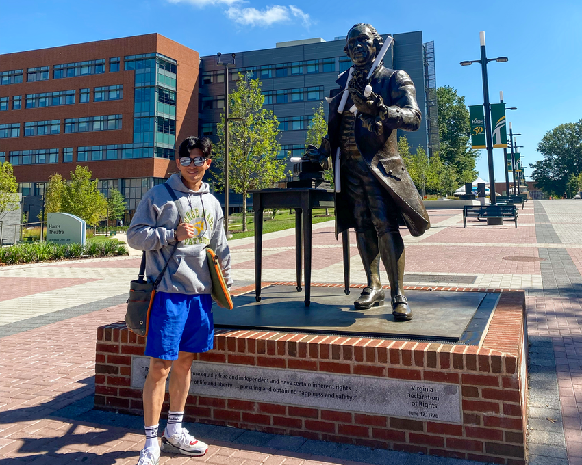 Kim standing with a stature of George Mason in Fairfax.