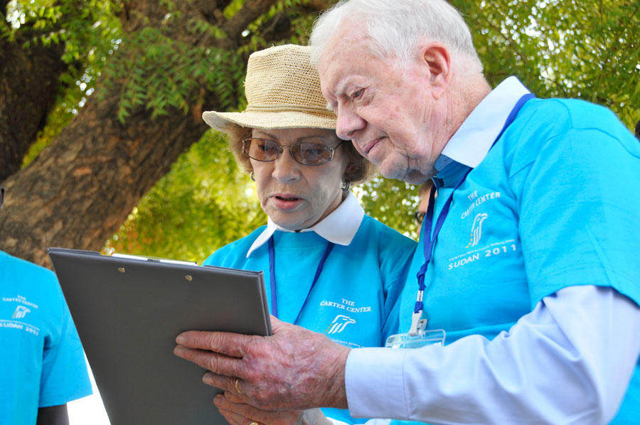 Jimmy and Rosalynn Carter look at a clipboard together. 