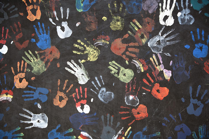 handprints on the ground made with many colors of paint