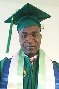 A headshot of Amadu Koroma. He is in green cap and gown for graduation.